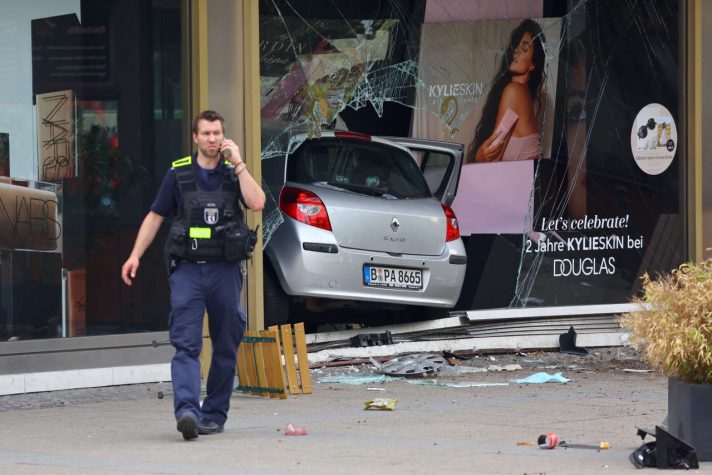 A police officer speaks on the phone near the car at crashed into a group of people and ended up in a storefront, injuring dozens and killing at least one, at Tauentzien Strasse near Kaiser Wilhelm Gedaedtniskirche church in Berlin, Germany June 8, 2022. REUTERS/Fabrizio Bensch